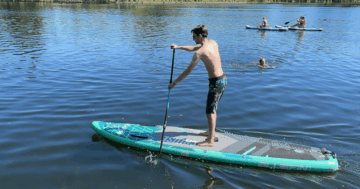 Paddler auf einem tuerkisen Bluefin Cruise SUP-Board auf einem See