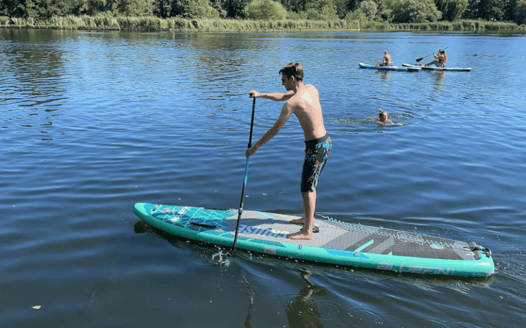 Paddler auf einem tuerkisen Bluefin Cruise SUP-Board auf einem See